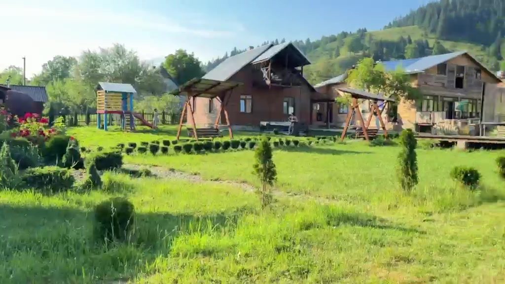 Зелена територія вілли з альтанками та горами навколо
